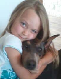 blue and rust female doberman with little girl