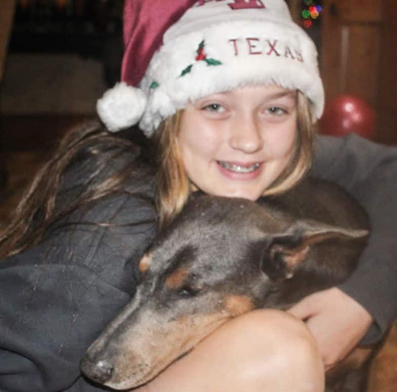 young girl with her pal a blue rust female doberman named Ella