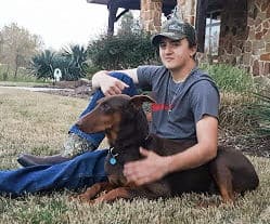 teenage boy with his best friend red rust doberman female named Sable