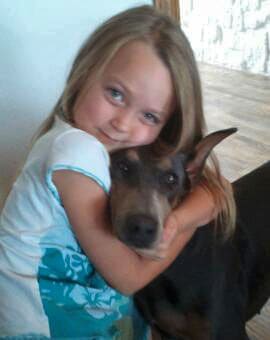 blue and rust female doberman with little girl